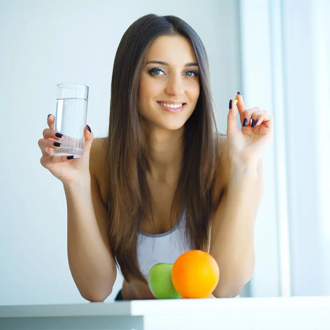 Persona disfrutando un vaso con jugo de naranja fresco, símbolo del consumo de vitamina C natural para fortalecer las defensas y mantener el bienestar con Alternativ.